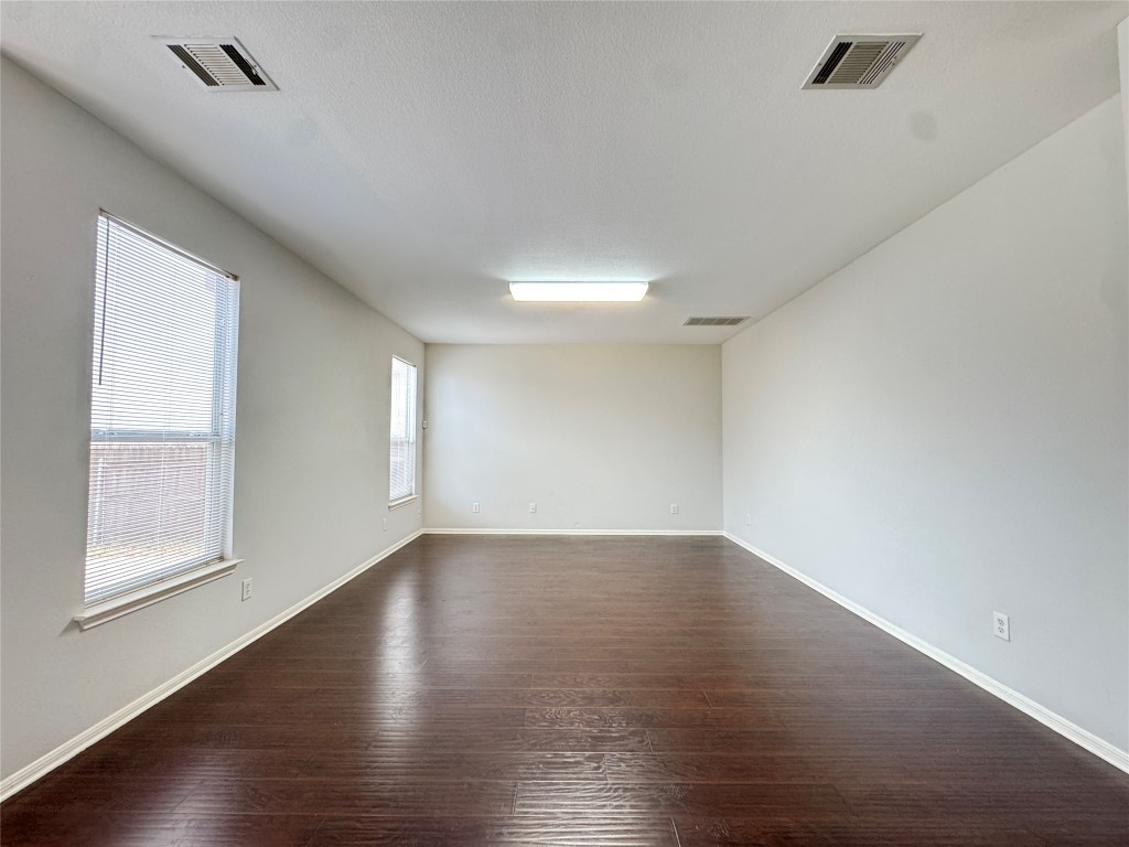 3404 Bratton Ridge Crossing Austin, TX 78728 - Photo 9 of 25 a view of an empty room with wooden floor and window