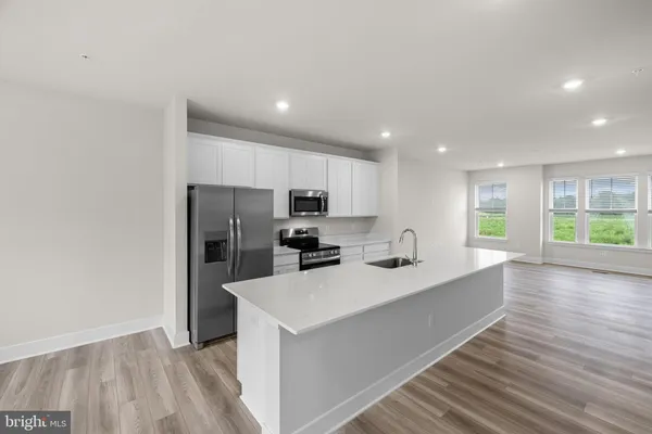 a kitchen with stainless steel appliances a refrigerator sink and microwave