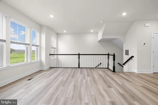 a view of a livingroom with wooden floor and a window