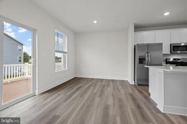a view of a kitchen with a sink refrigerator and wooden floor