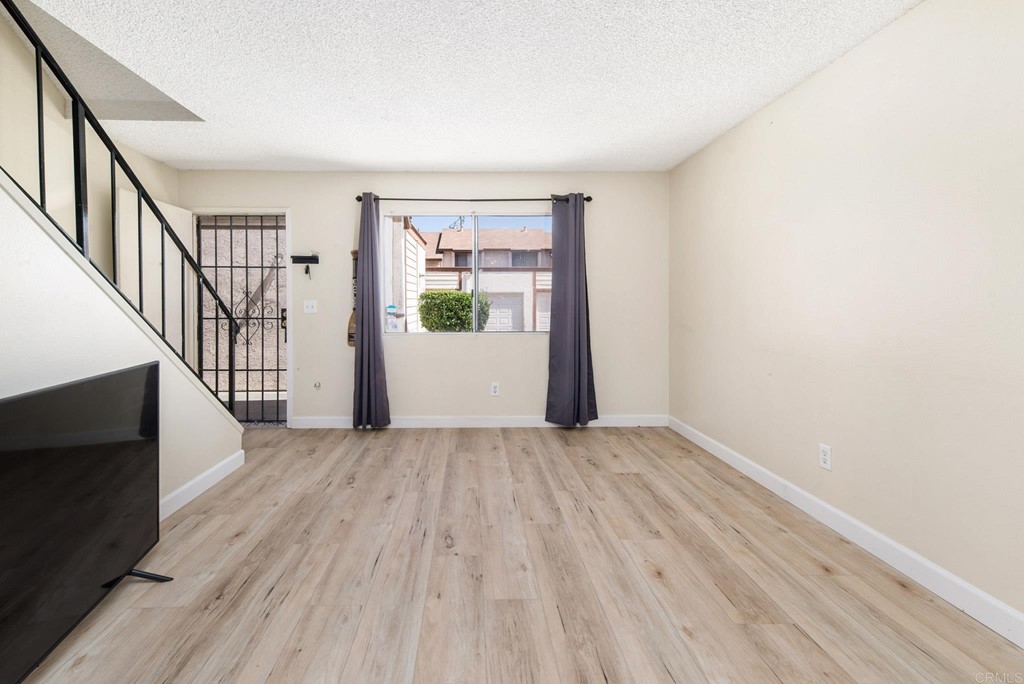 5130 North River Road, Unit F Oceanside, CA 92057 - Photo 2 of 15 a view of an empty room with wooden floor and a window