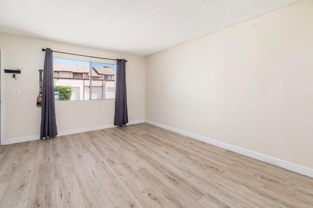 5130 North River Road, Unit F Oceanside, CA 92057 - Photo 6 of 15 an empty room with wooden floor and windows