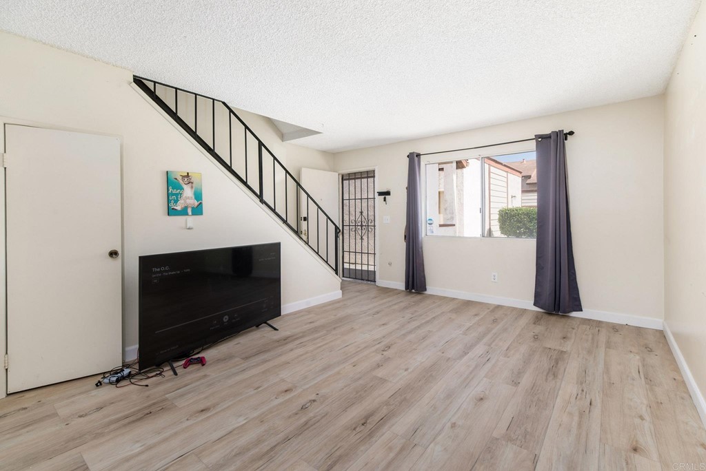5130 North River Road, Unit F Oceanside, CA 92057 - Photo 7 of 15 a view of empty room with wooden floor and fan
