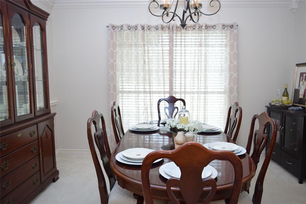 4201 Glistening Spring Rowlett, TX 75088 - Photo 12 of 33 Dining area featuring a central chandelier, crown molding, and a window with blinds