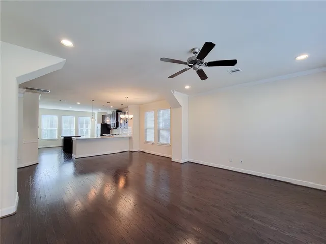 a view of empty room with wooden floor and window