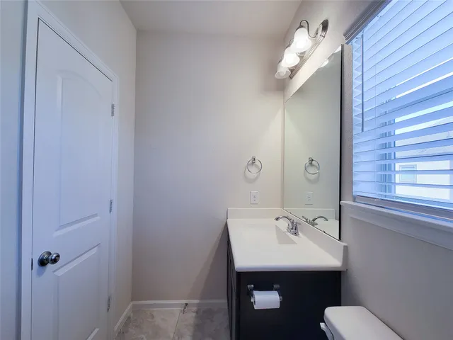 a bathroom with a sink mirror and toilet