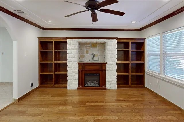 a view of an empty room with a fireplace and a window