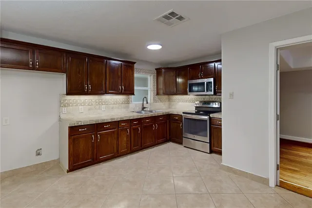 a kitchen with granite countertop stainless steel appliances and cabinets