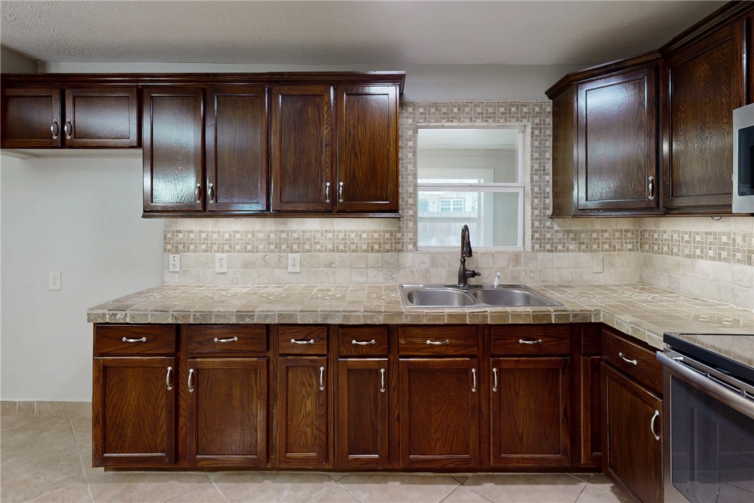 903 Travis Street Bryan, TX 77803 - Photo 7 of 20 a kitchen with a sink and cabinets
