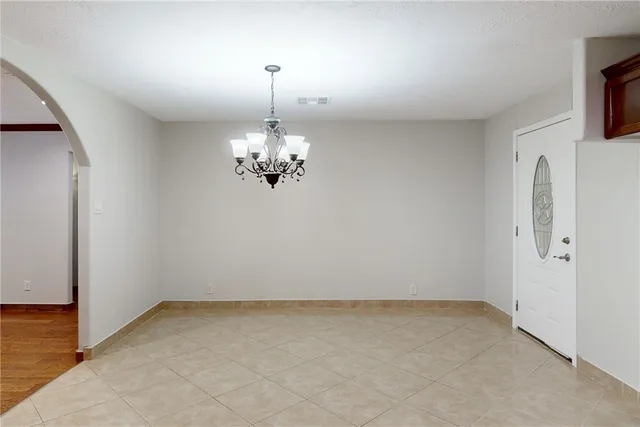 a view of a room with steel appliances and chandelier
