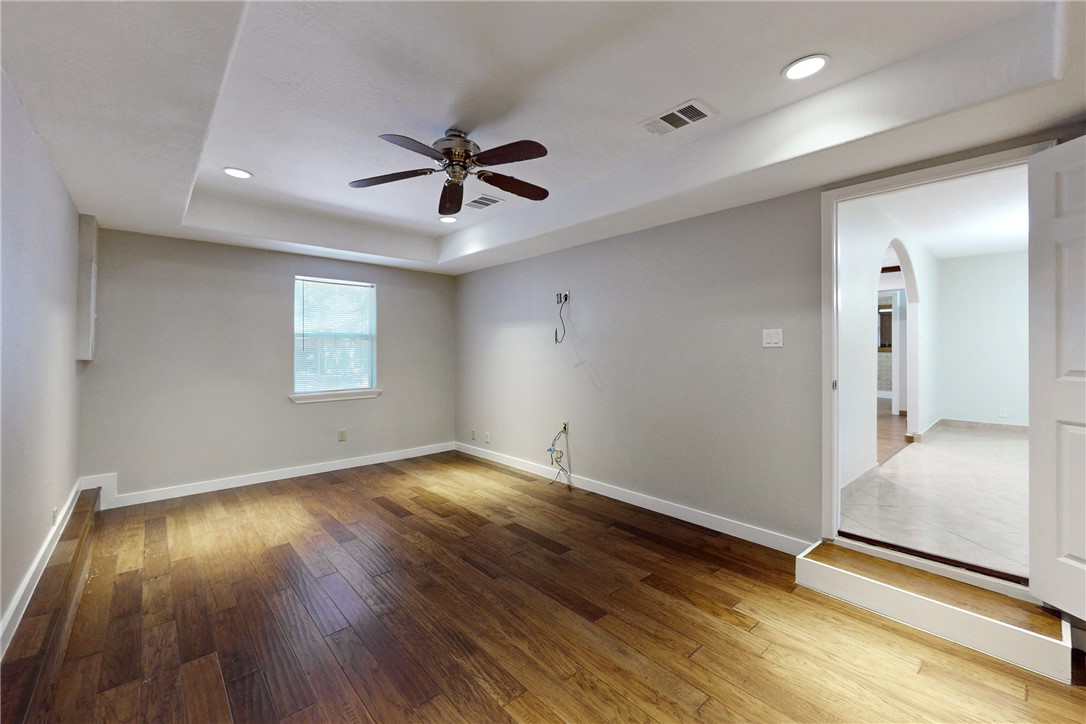 903 Travis Street Bryan, TX 77803 - Photo 10 of 20 a view of empty room with wooden floor and fan
