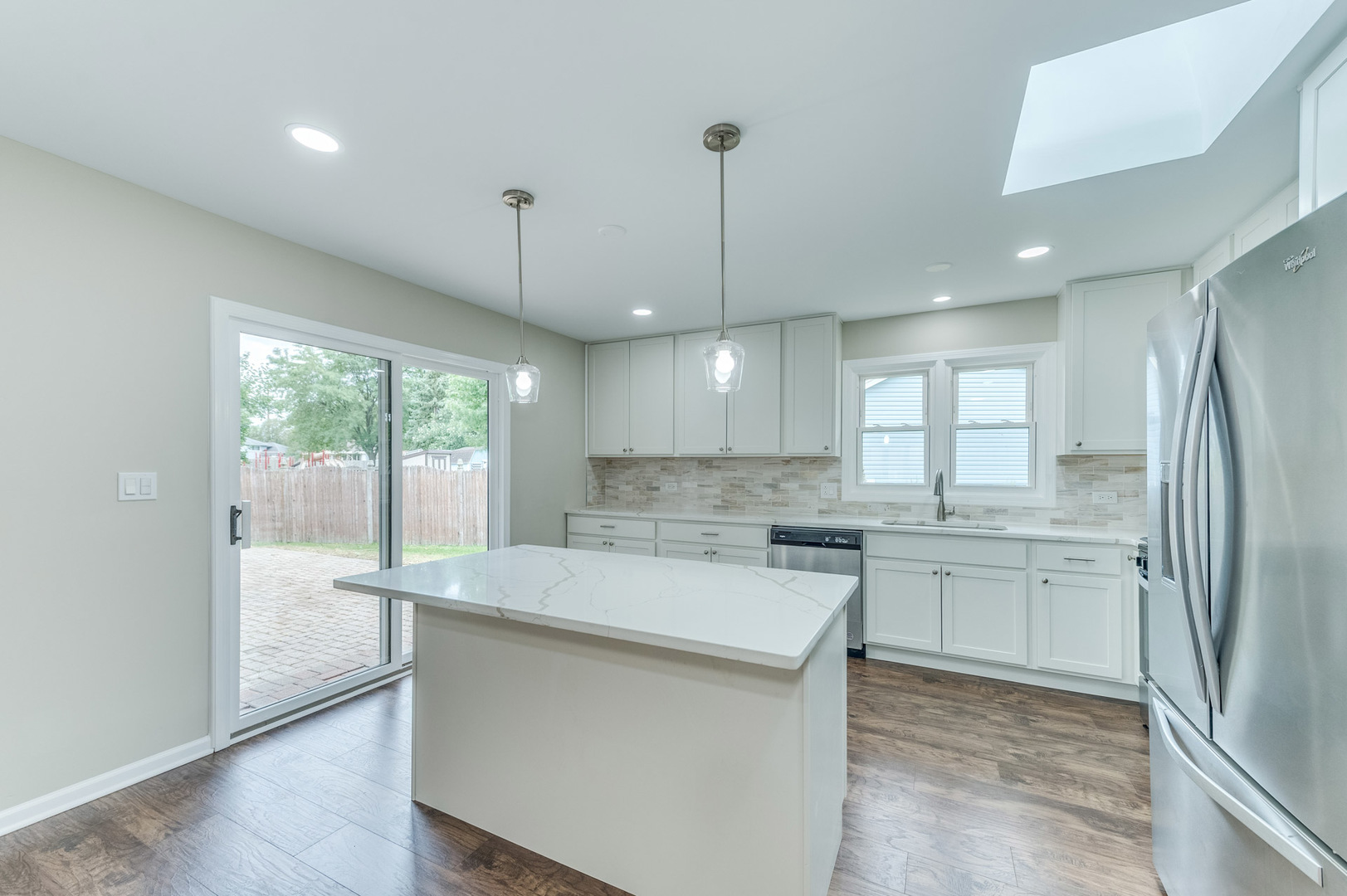 16539 Timberview Drive Plainfield, IL 60586 - Photo 10 of 26 a large kitchen with kitchen island a large window a sink stainless steel appliances and cabinets