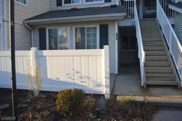 a view of a house with a small yard and wooden floor and fence