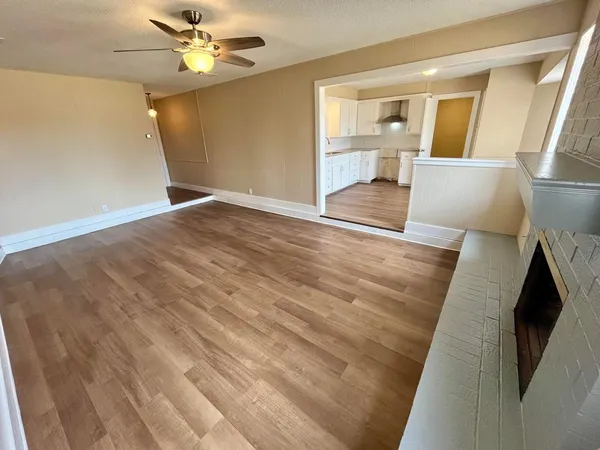 an empty room with windows and fan