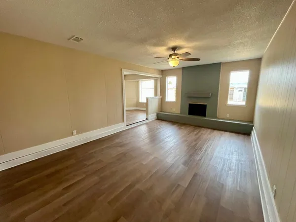 a view of an empty room with a fireplace and a window
