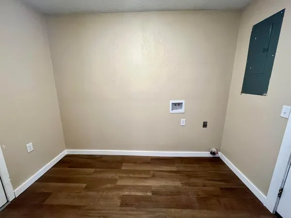a view of an empty room with wooden floor