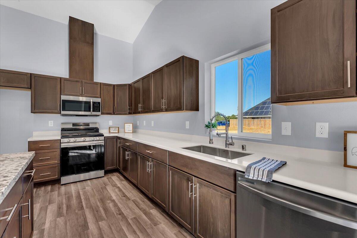 1565 Carl Court Red Bluff, CA 96080 - Photo 17 of 49 a kitchen with kitchen island granite countertop a sink stainless steel appliances and cabinets