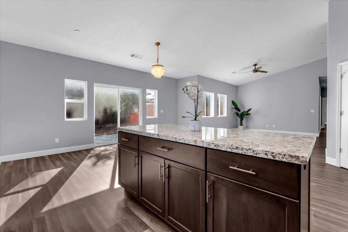 1565 Carl Court Red Bluff, CA 96080 - Photo 18 of 49 a large kitchen with granite countertop a sink and dishwasher cabinets with wooden floor