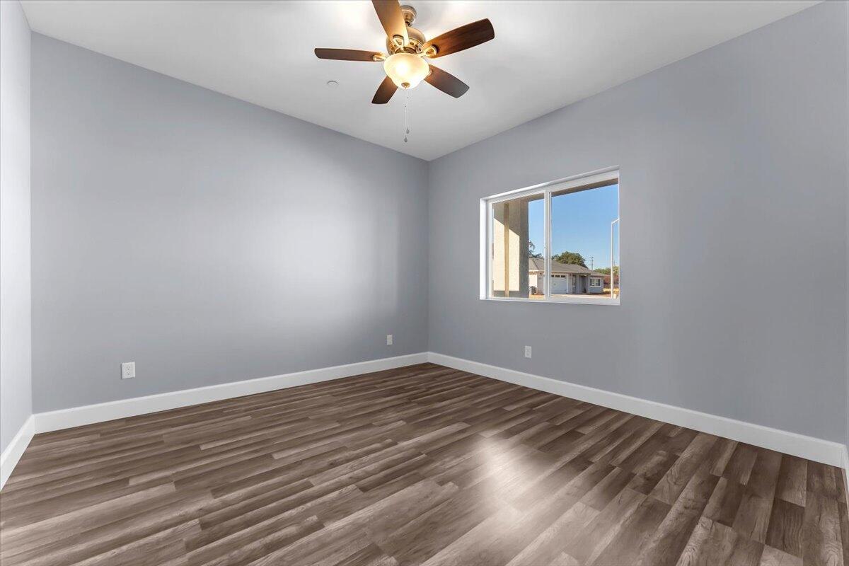 1565 Carl Court Red Bluff, CA 96080 - Photo 6 of 49 a view of an empty room with window and wooden floor