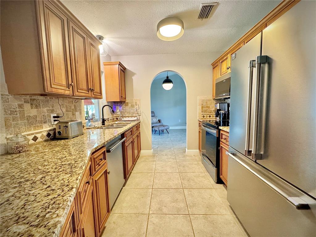 9405 Spring Circle Port Charlotte, FL 33981 - Photo 7 of 24 a kitchen with stainless steel appliances granite countertop a refrigerator and a sink