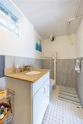 a bathroom with a granite countertop sink and a mirror