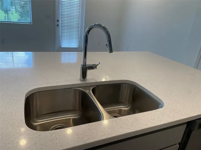 a kitchen with a sink a refrigerator and chandelier