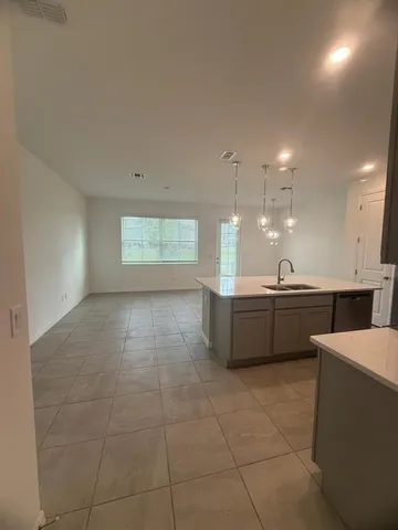 a large room with kitchen island a sink a counter and a fireplace