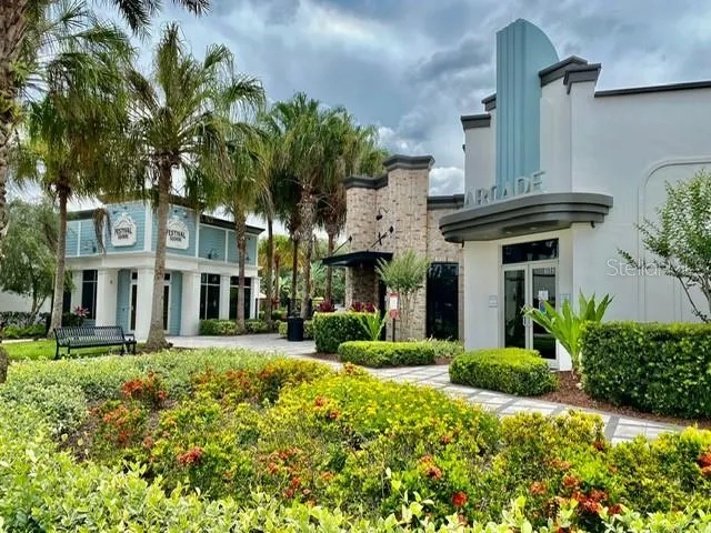 a view of patio with chairs and tables with chairs under an umbrella with a barbeque