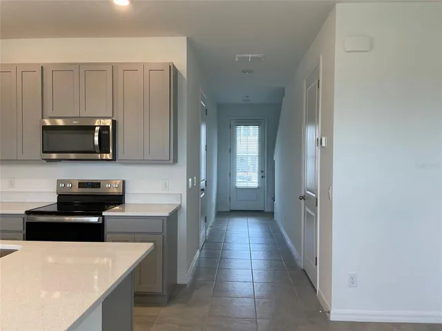 a kitchen with stainless steel appliances granite countertop a refrigerator and a stove top oven