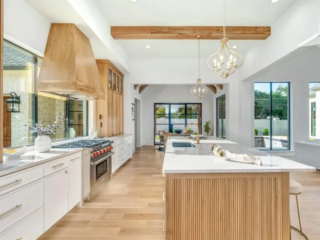 a large white kitchen with a large window