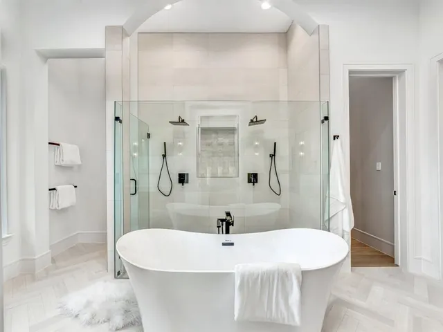 a spacious bathroom with a tub sink and mirror