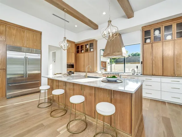 a kitchen with stainless steel appliances granite countertop a sink a stove and a wooden floors
