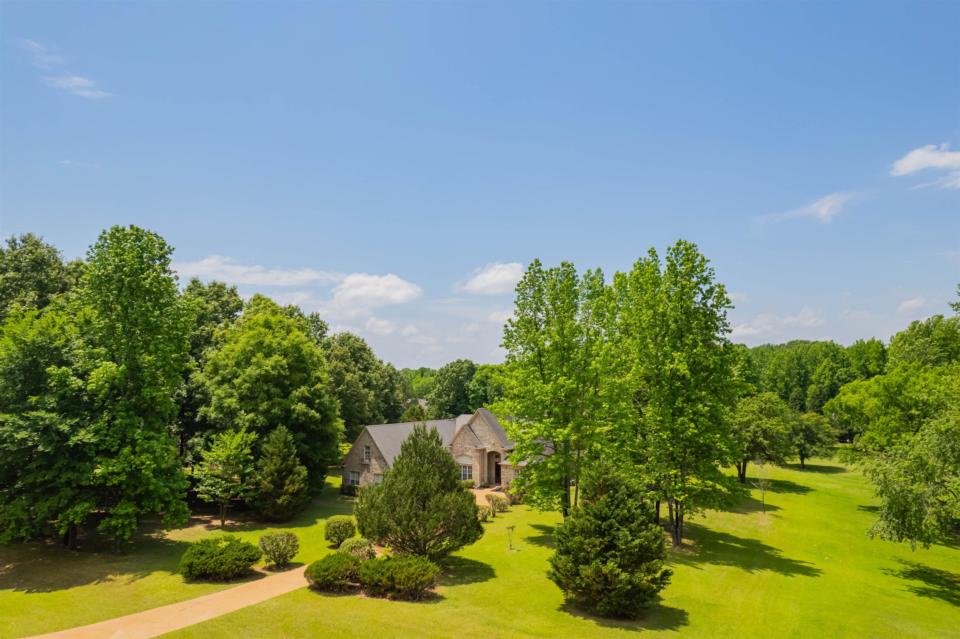 5035 Brian Ridge Road Arlington, TN 38002 - Photo 34 of 40 Expansive property featuring a stone exterior residence, a paved circular driveway, mature trees, manicured lawns, and established landscaping