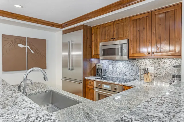 a kitchen with stainless steel appliances granite countertop a sink and a microwave