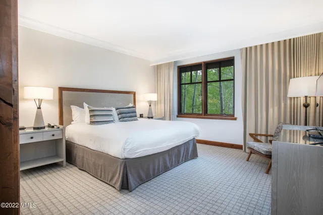 a bedroom with a large bed and a lamp on table