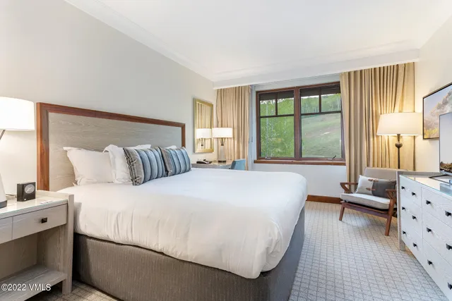 a bedroom with a bed a couch and large window