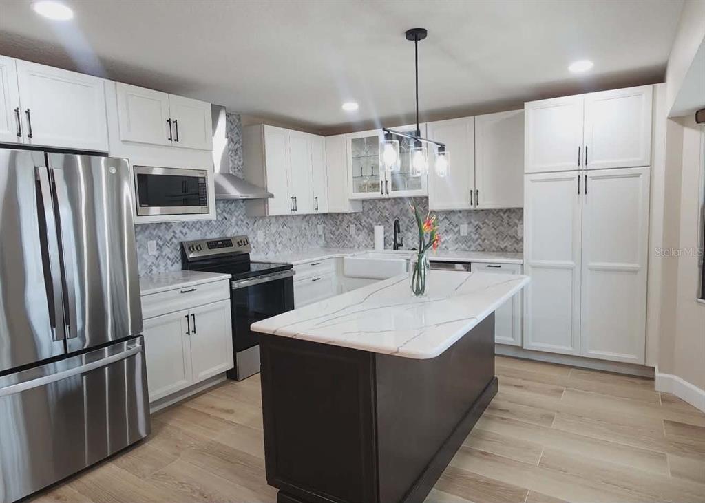 1425 South Homestead Point Inverness, FL 34450 - Photo 21 of 72 a kitchen with kitchen island a sink stainless steel appliances and refrigerator