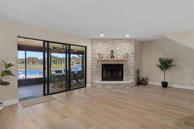 a kitchen with stainless steel appliances kitchen island granite countertop a sink a stove a refrigerator and white cabinets with wooden floor