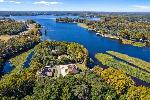 an aerial view of a house with a yard and lake view