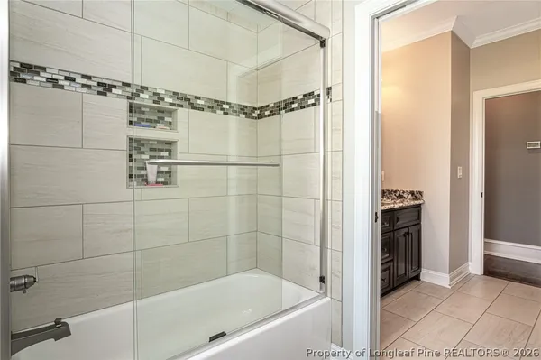 a bathroom with a sink mirror and shower