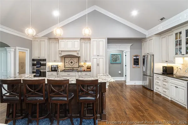 a living room with furniture a flat screen tv and a floor to ceiling window
