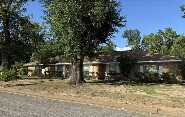 a view of a house with a yard and tree s