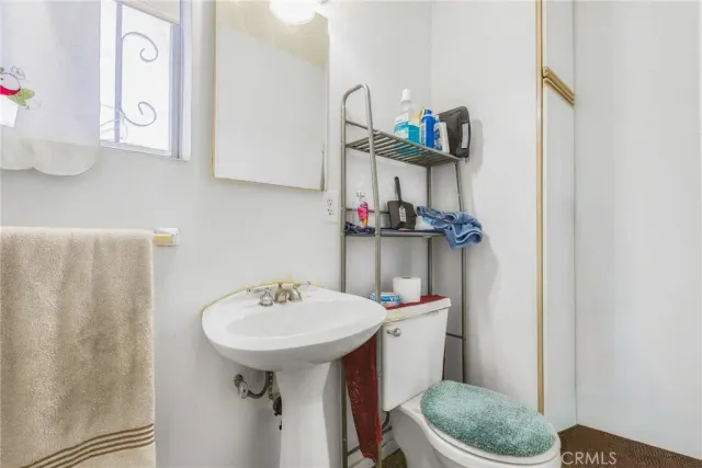 a bathroom with a sink toilet and a mirror