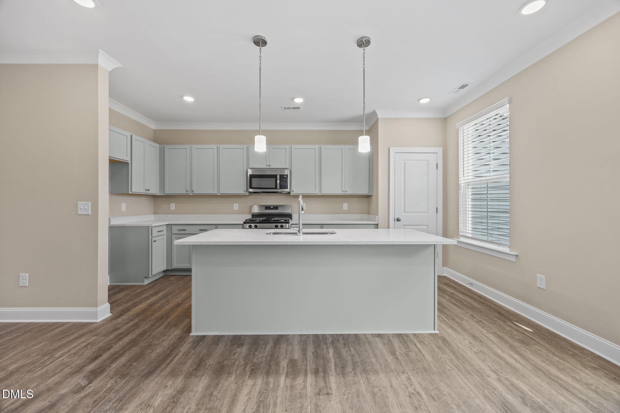 141 Pearl Street, Unit 9 Garner, NC 27529 - Photo 4 of 26 a kitchen with kitchen island a sink a center island a stove and a window