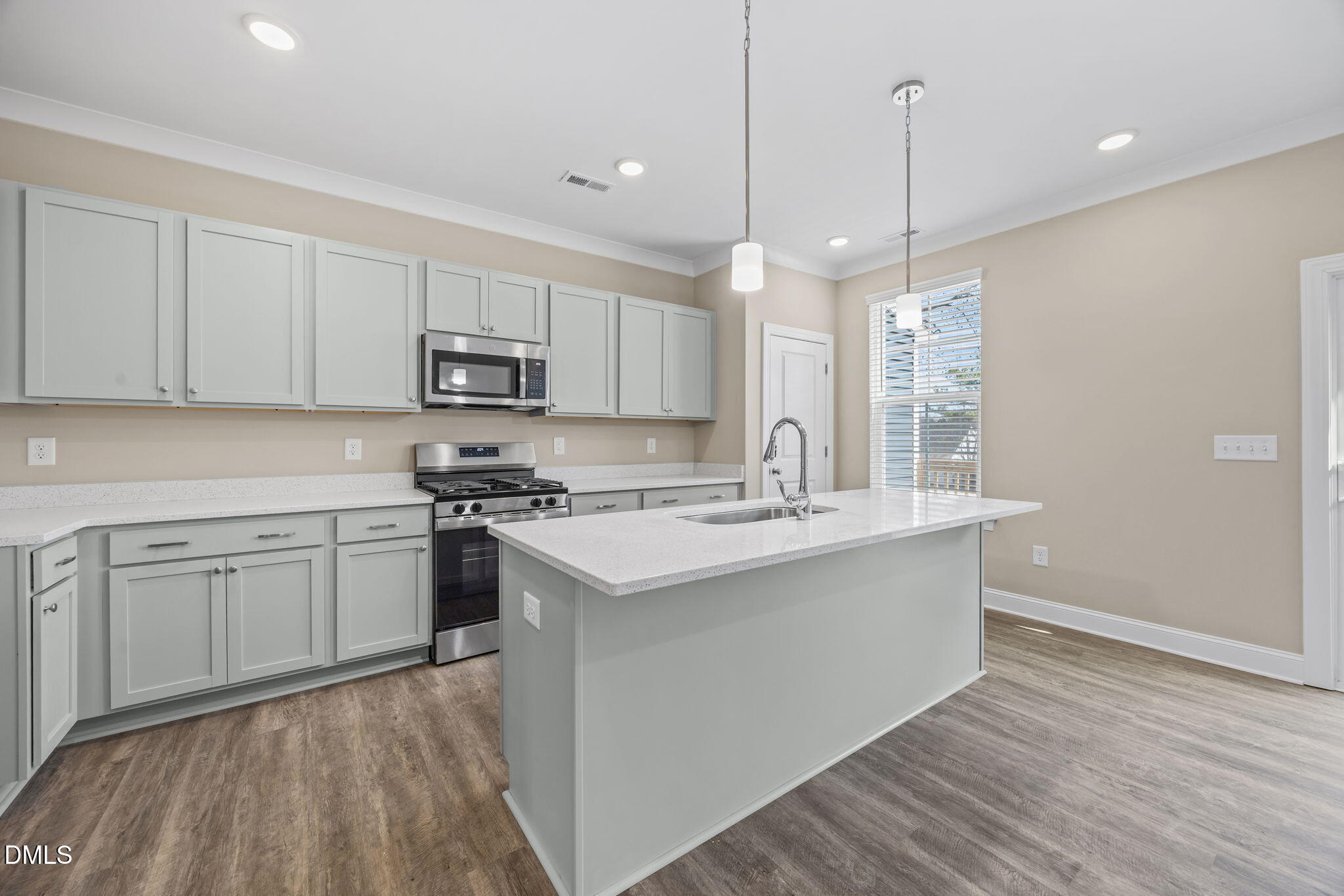 141 Pearl Street, Unit 9 Garner, NC 27529 - Photo 7 of 26 a kitchen with stainless steel appliances granite countertop a sink a stove a refrigerator and island with wooden floor
