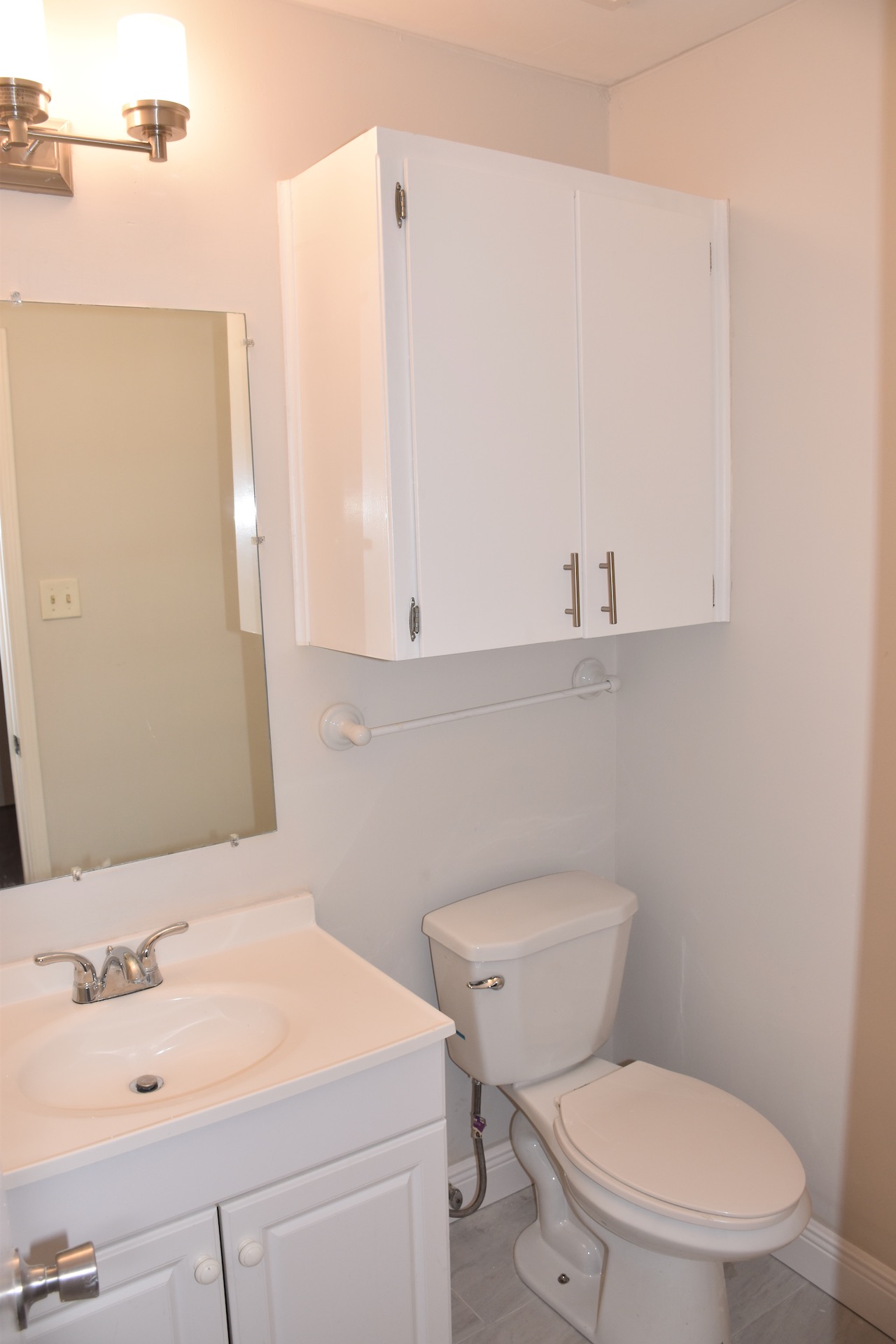 1810 Rawhide Loop Round Rock, TX 78681 - Photo 27 of 29 Bathroom featuring a white vanity with integrated sink, chrome faucet, wall-mounted mirror, and overhead lighting