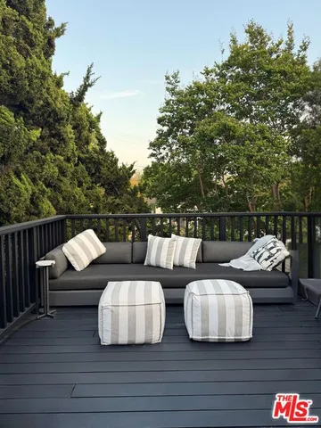 a bedroom with a bed a dresser and windows