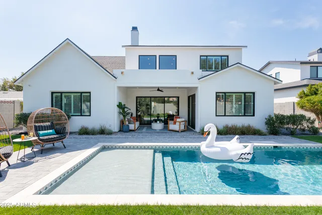 a view of a house with swimming pool and sitting area
