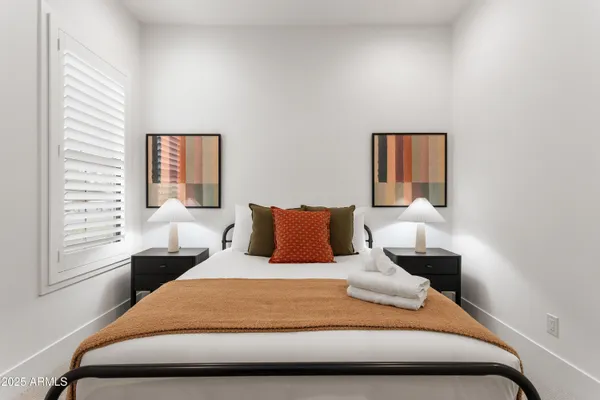 a bedroom with a bed lamp and a window