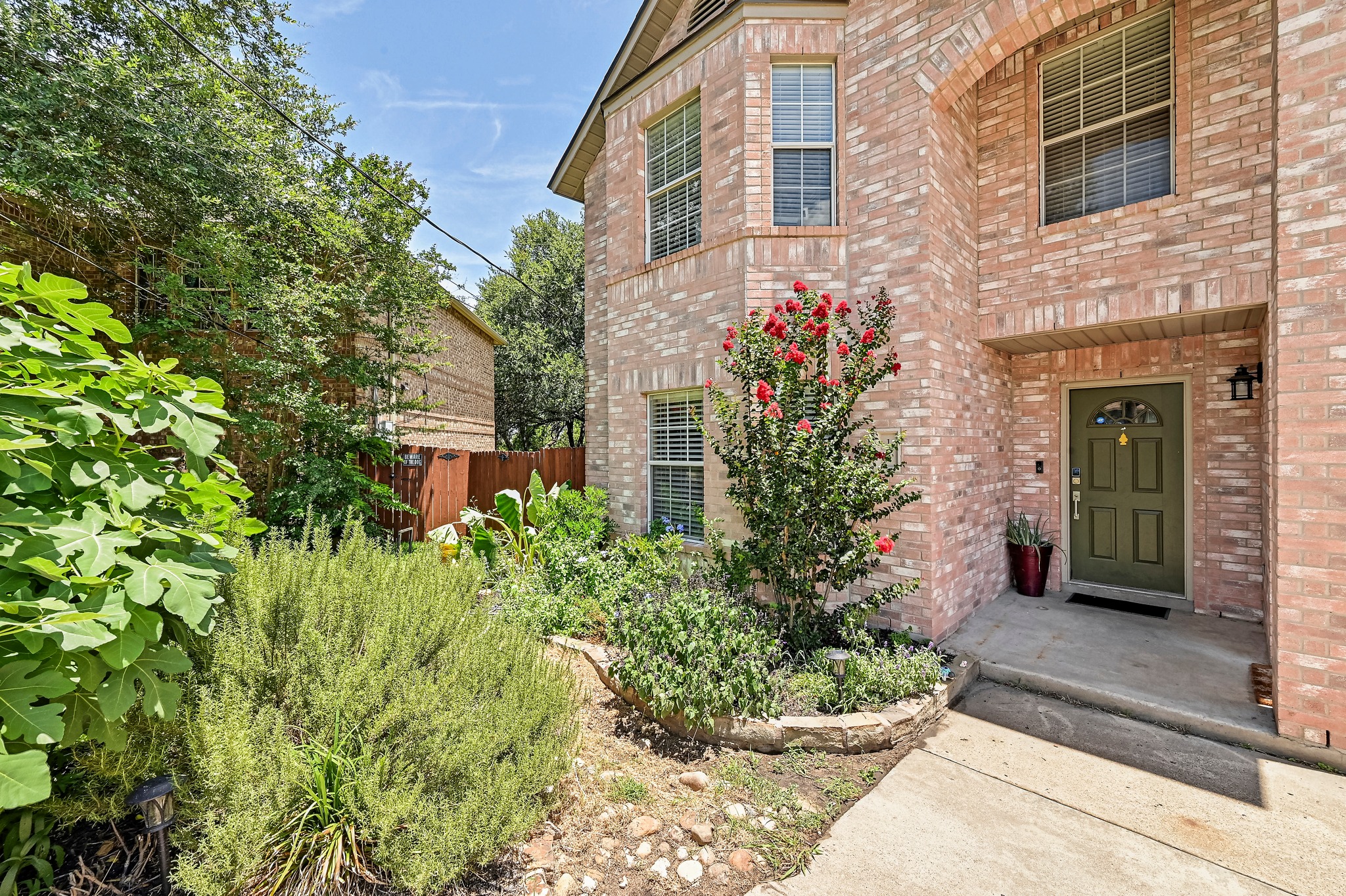 104 North Sumac Lane Georgetown, TX 78633 - Photo 5 of 40 A well-maintained brick facade home with lush landscaping and a welcoming entry.